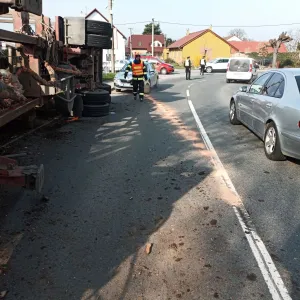 Návěs dřeva se převrátil na chodník